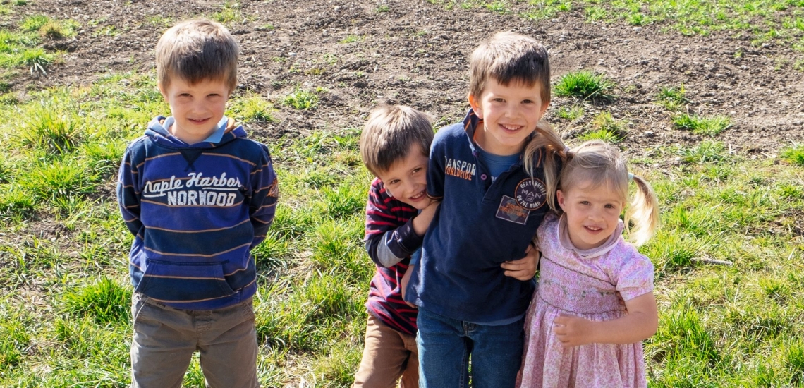 Vier Kinder auf Rasen 