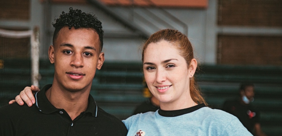 Junge Frau legt jungem Mann die Hand auf die Schulter 