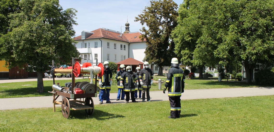 Feuerwehrleute haben sich auf Wiese aufgestellt