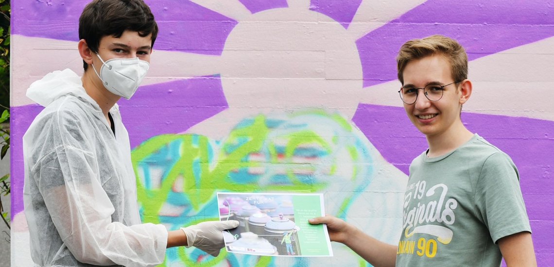 Lennart und ein Jugendlicher vor der Wand mit dem Graffiti