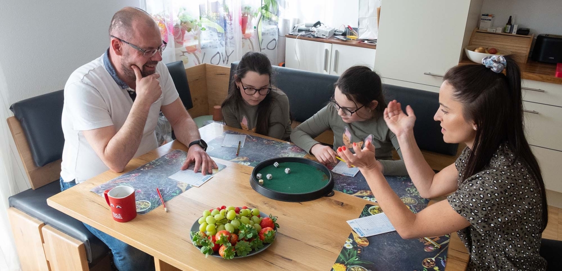 eine Familie beim Kniffelspielen