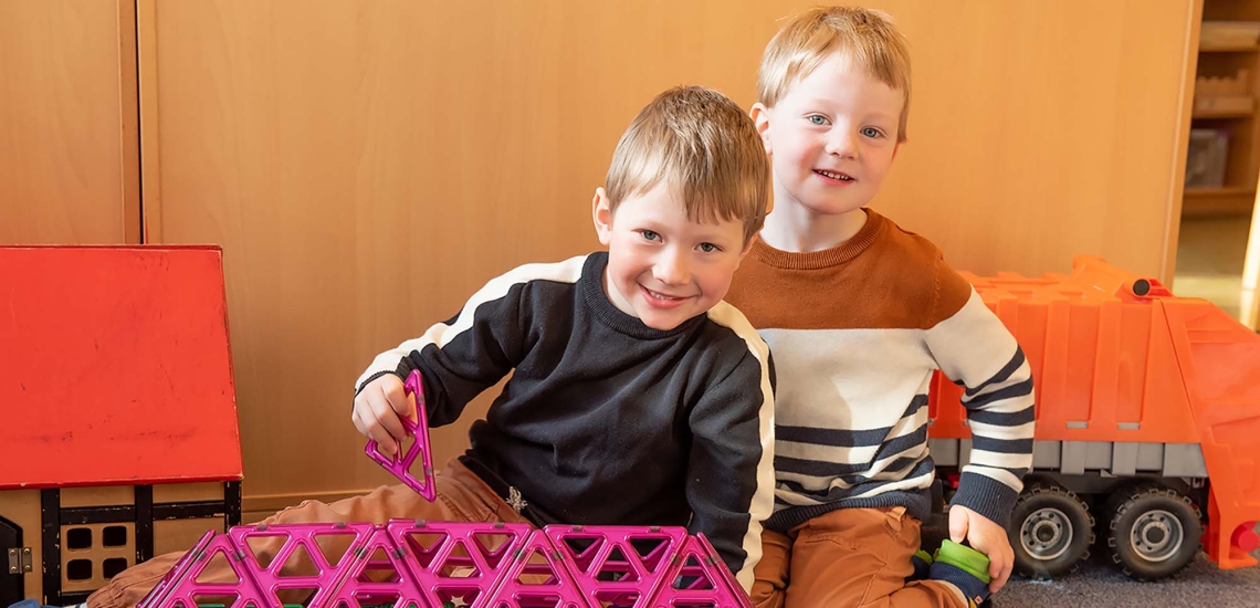 zwei Kinder mit Bauklötzen im Kindergarten