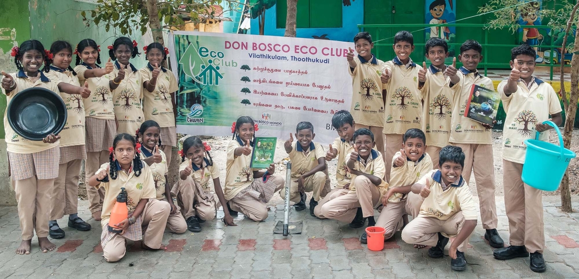 Gruppenbild von Jugendlichen, die ein Öko-Klub Schild und ihren Daumen hochhalten.