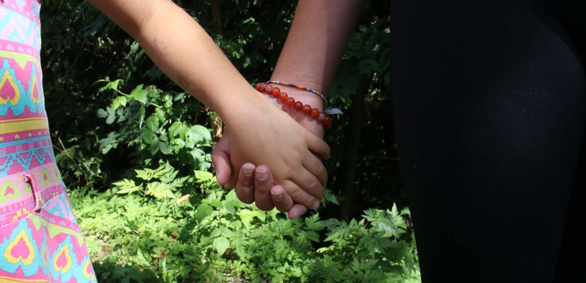 Zwei Mädchenhände halten sich gegenseitig.