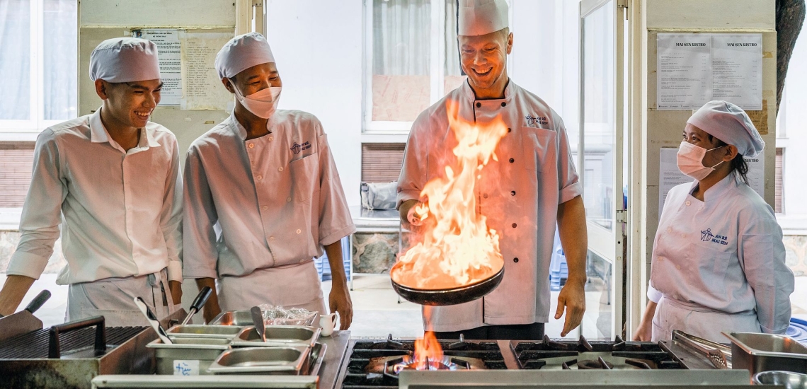 Kochschüler und Ausbilder am Herd in der Gastronomieschule von Don Bosco in Ho Chi Minh City