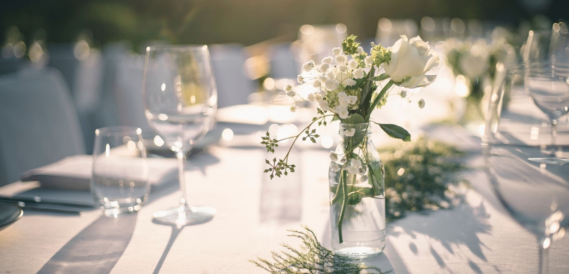 Festlich gedeckter Tisch mit Gläsern und Blumenschmuck für Hochzeitsfeier 