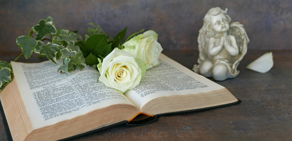 Aufgeschlagene Bibel mit Blumen und Engel 