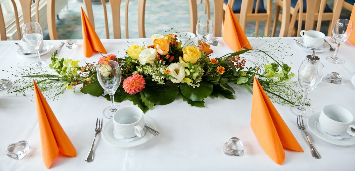 Gedeckter Kaffeetisch im Restaurant mit Blumenschmuck 