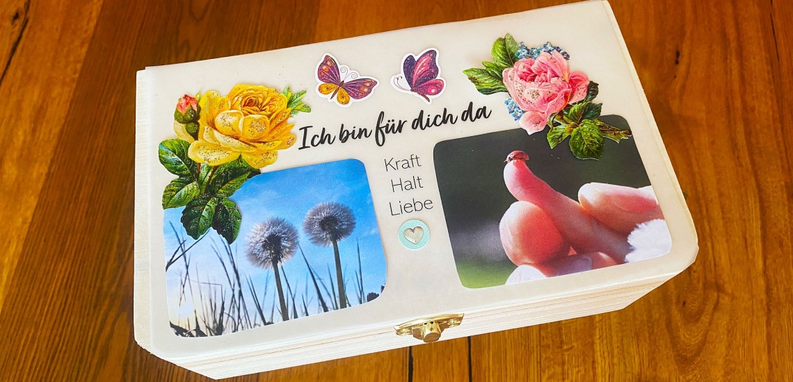Mit Fotos und Stickern beklebte Holzbox mit Schrift "Ich bin für dich da, Kraft, Halt, Liebe" 