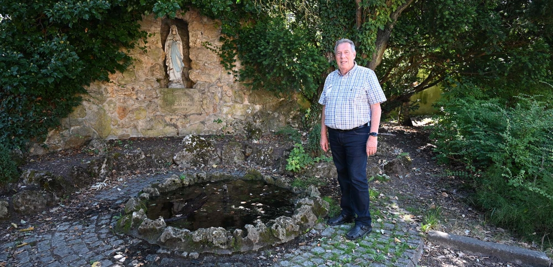 Otto Hamsa steht draußen vor einer Marienstatue.