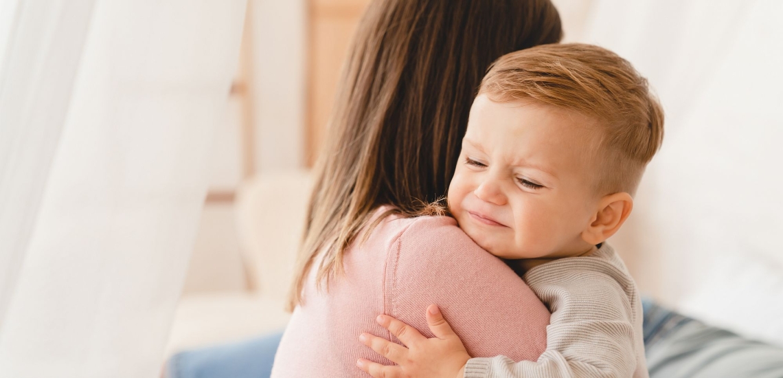 Baby klammert sich weinend an Mutter 