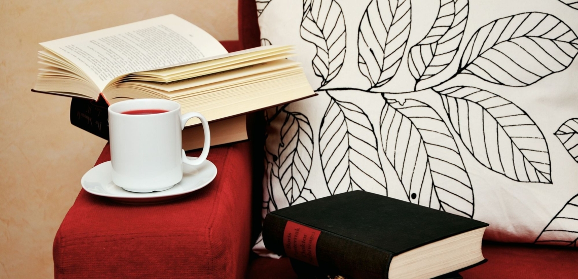 Bücher und Tasse Tee auf Sofa 