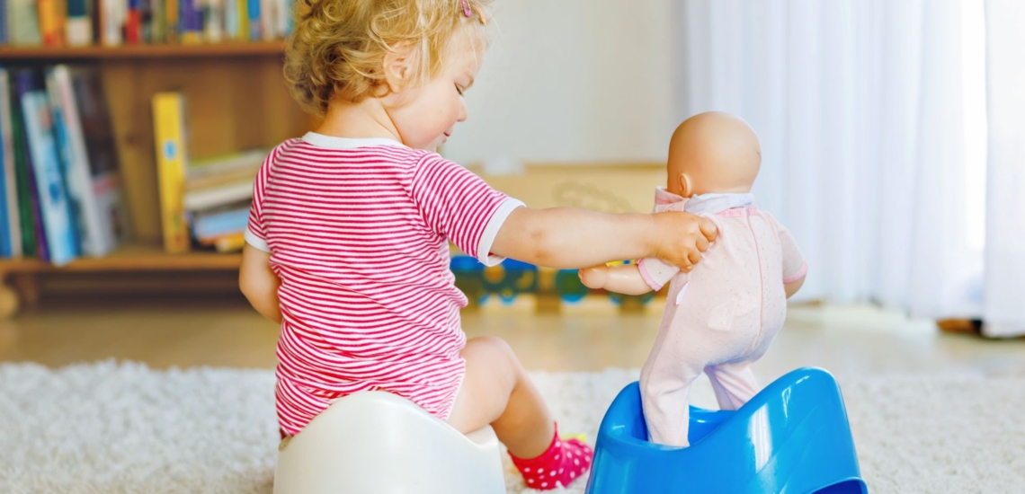 Kind auf Töpchen mit Puppe 