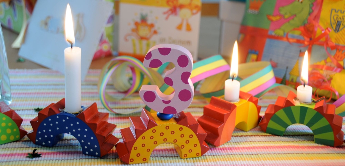 Dekoration zum Kindergeburtstag mit Geschenken und drei Kerzen 