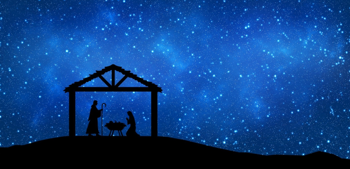 Stall mit Maria Josef und Jesuskind vor blauem Himmel mit Sternen