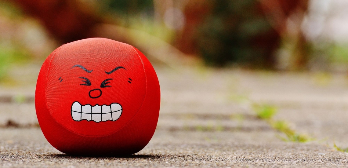 roter Antistressball mit wütendem Gesicht 