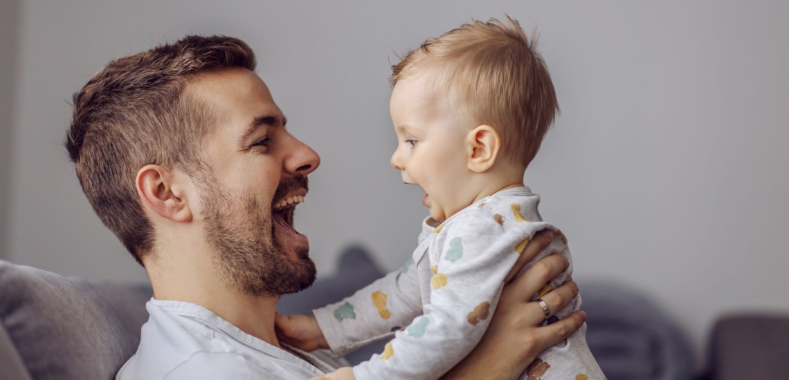 Vater und Baby lachen sich an 