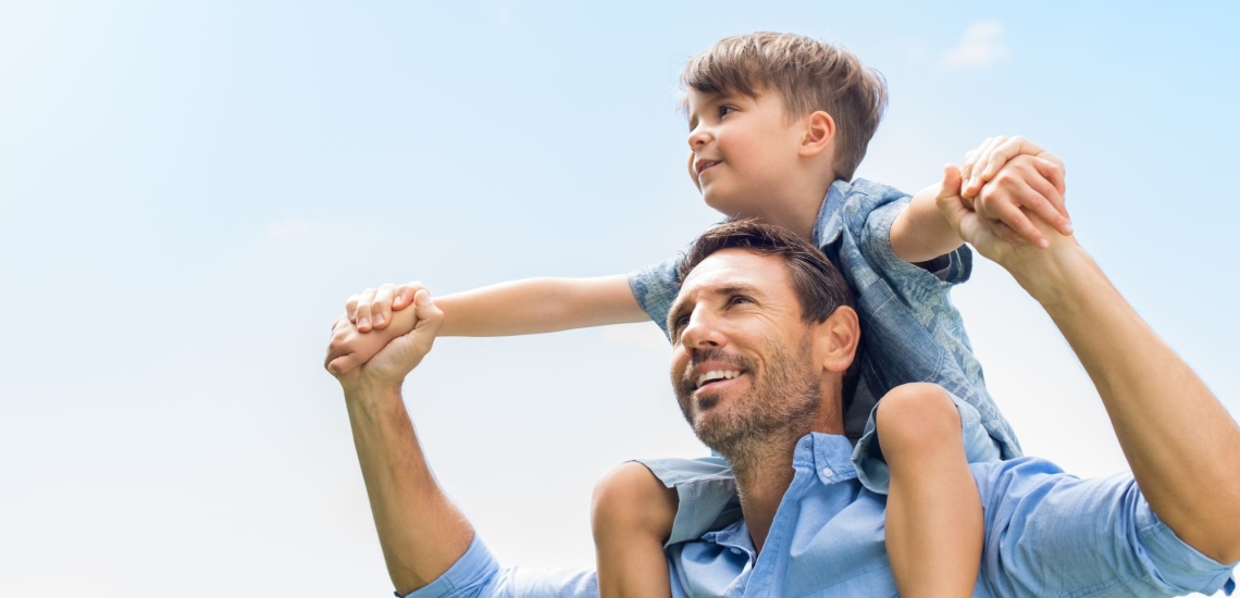 Vater froh mit Sohn auf seinen Schultern 