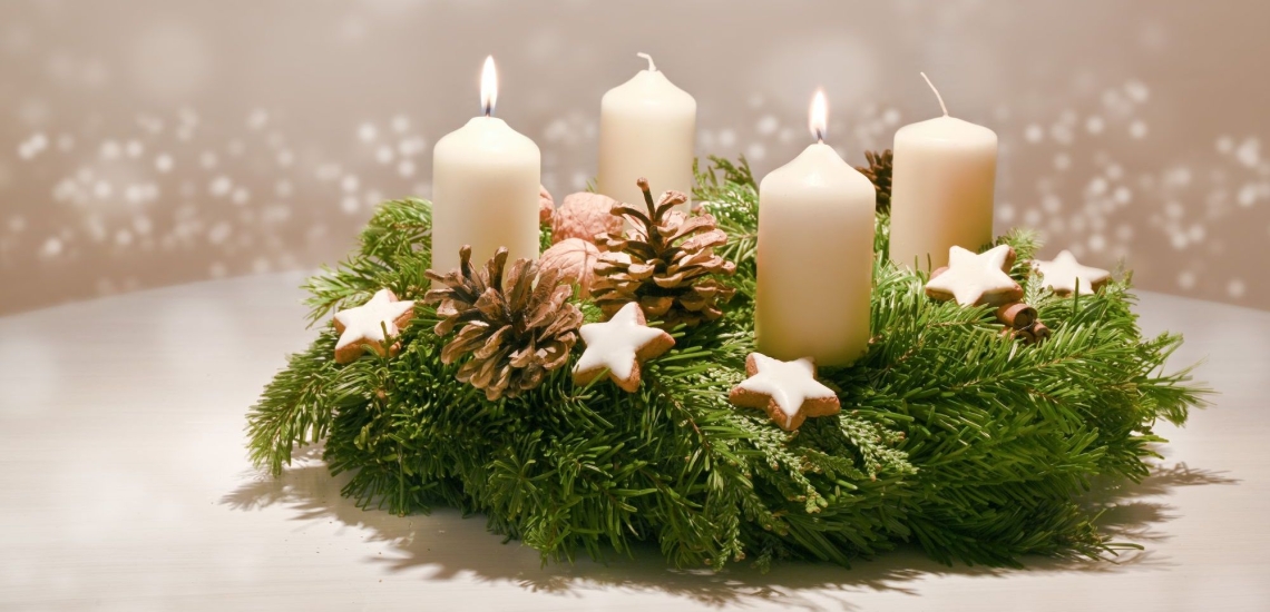 Adventskranz mit zwei brennenden weißen Kerzen