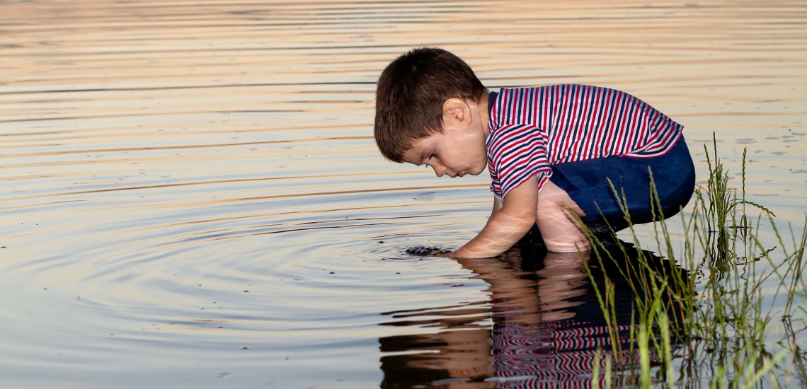 Junge spielt am Wasser