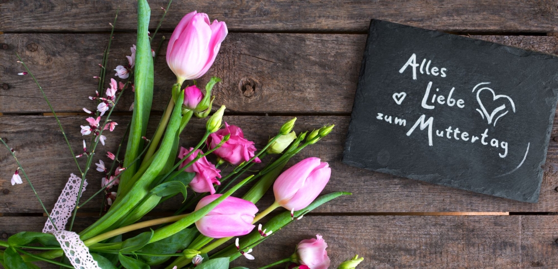 Blumenstrauß und Schiefertafel mit Aufschrift Alles Liebe zum Muttertag 