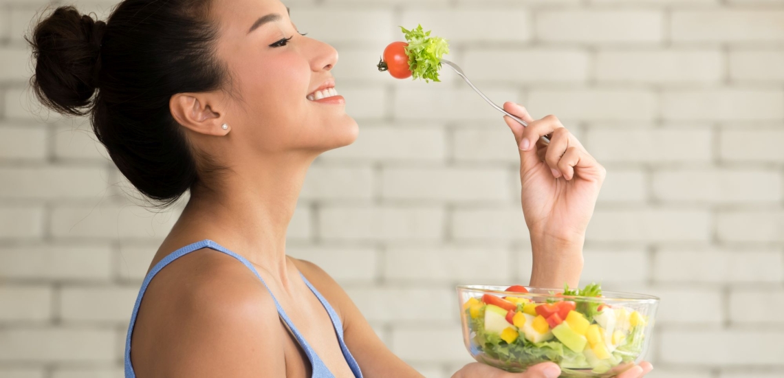 Jugendliche isst genüsslich Salat