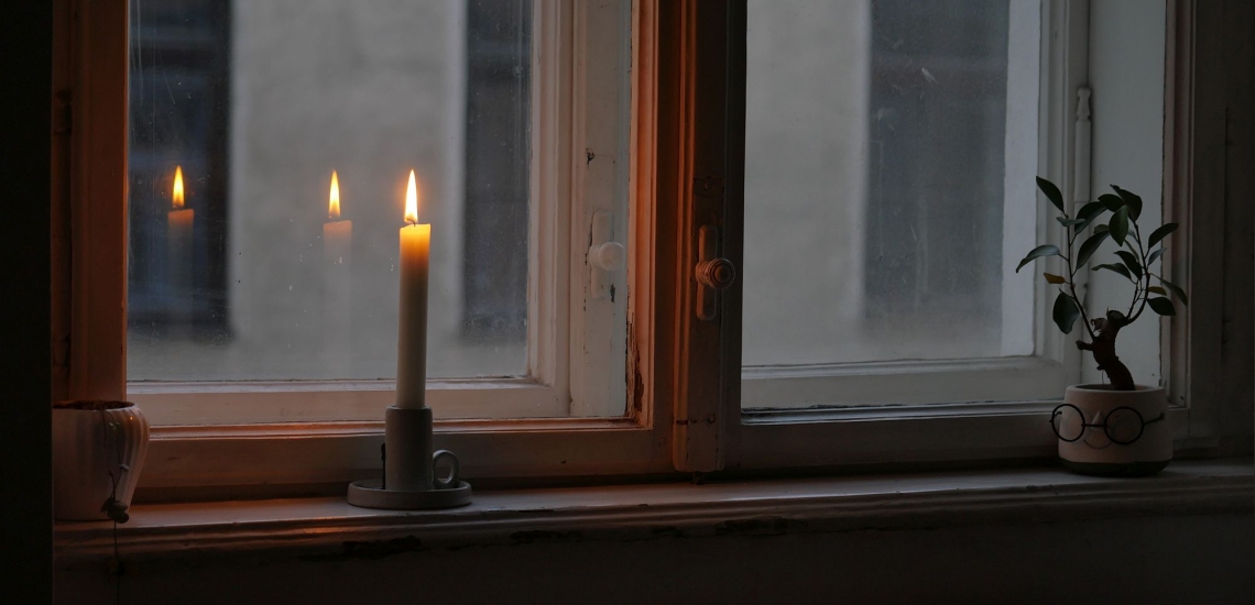 Brennende Kerze auf dem Fensterbrett 
