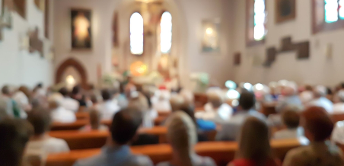 Verschwommener Innenraum einer Kirche mit Gläubigen 