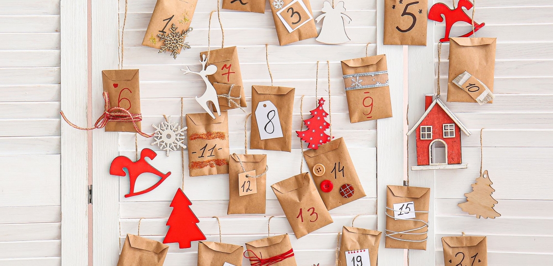 Adventskalender aus an Schnüren aufgehängten Papiertütchen mit Beschriftung und Dekoration