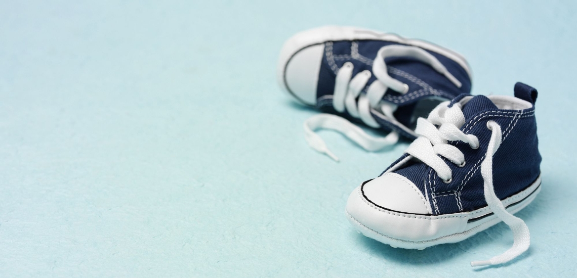 Babyschuhe liegend vor leerem Hintergrund 