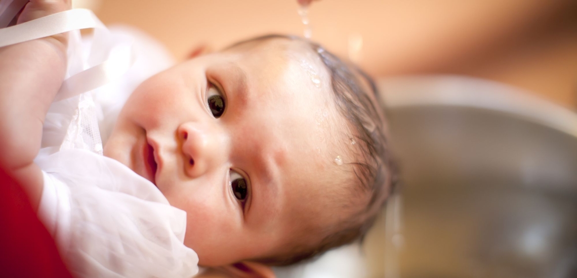 Baby über dessen Kopf Wasser rinnt 