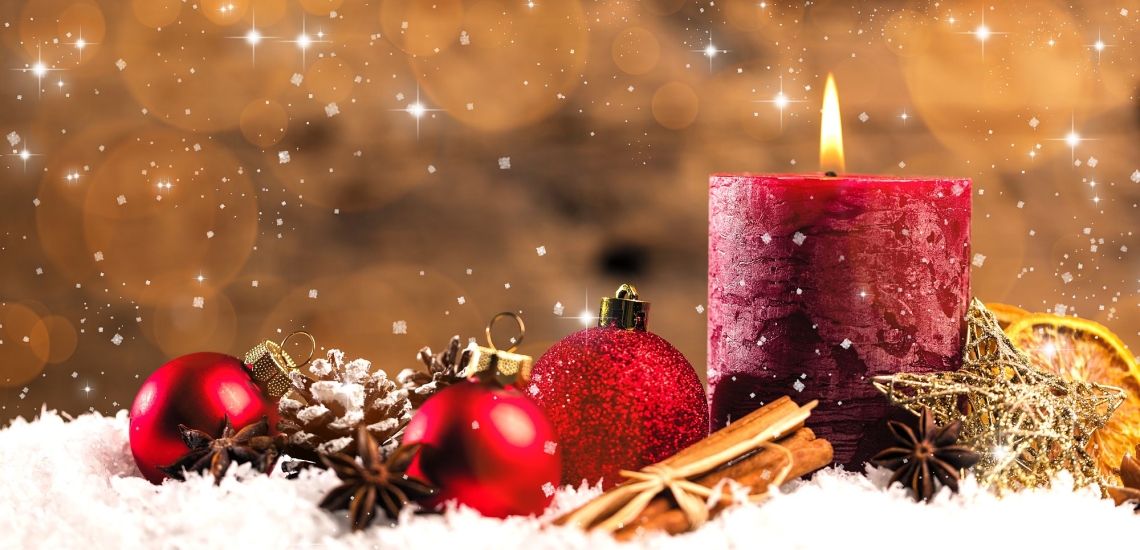 Stimmungsvolle Weihnachtsdekoration mit Kerze, Christbaumkugeln und Tannenzapfen 