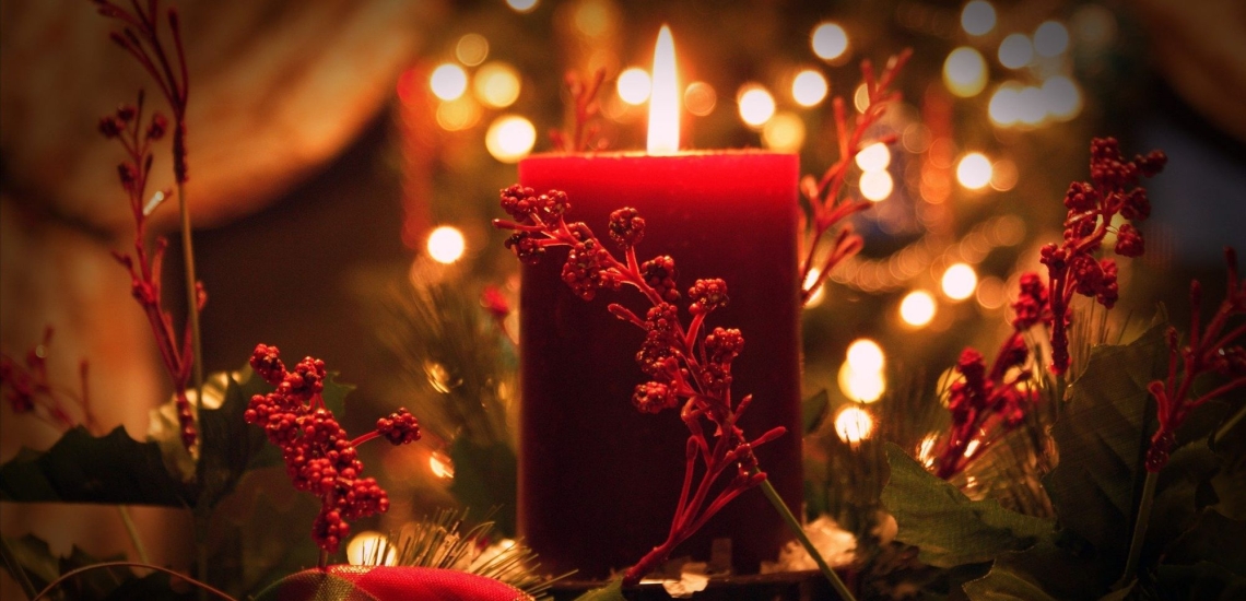 Weihnachtliches Arrangement mit Kerze, Lichtern und Zweigen 