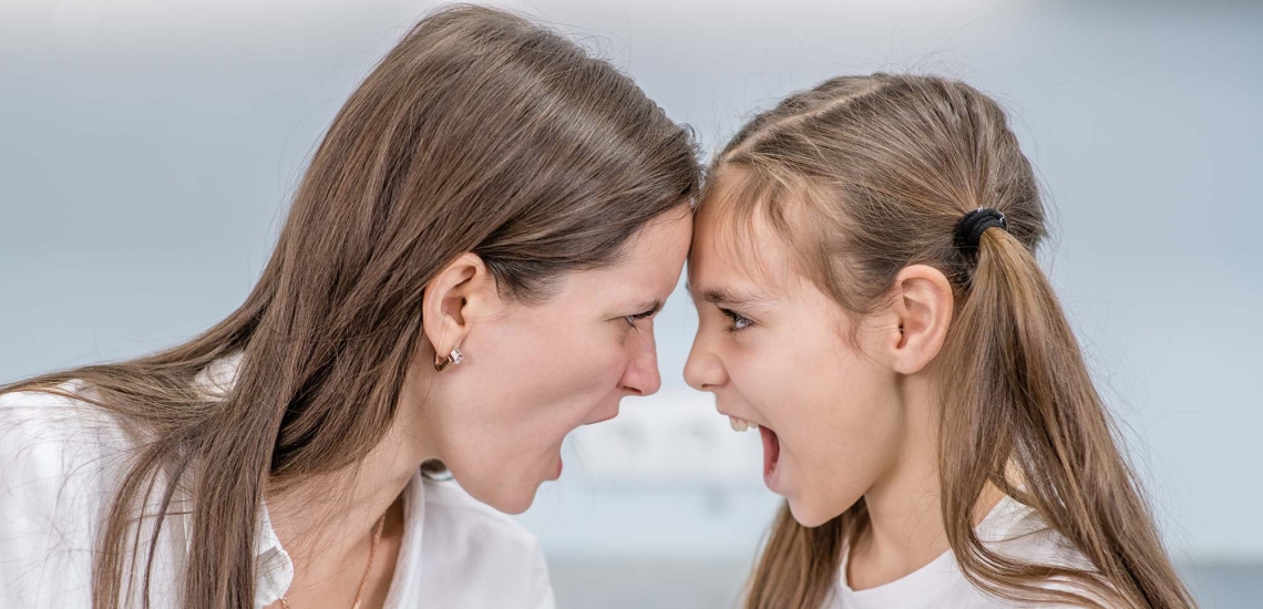 Eine Mutter und ihre Tochter stehen sich gegenüber und schreien sich an.