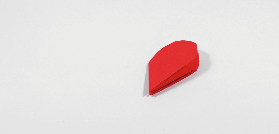 rotes zusammengefaltetes und zu einem halben Herz geschnittenes Papier