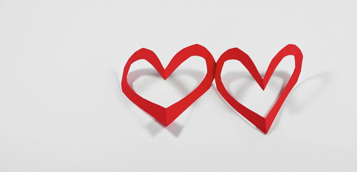 Girlande aus zwei roten Papierherzen mit ausgeschnittener Mitte