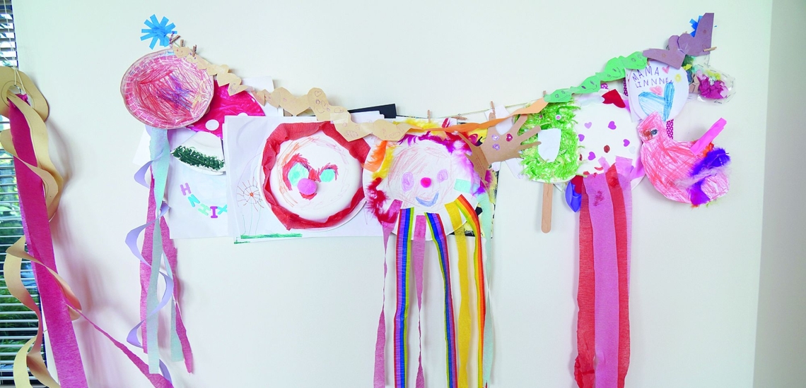Kunstwerke von Kindern mit Klammern an einer Schnur befestigt 