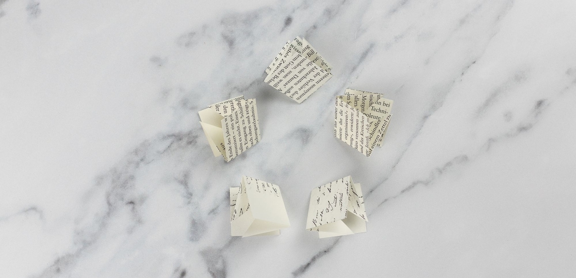 fünf gefalzte Papierquadrate