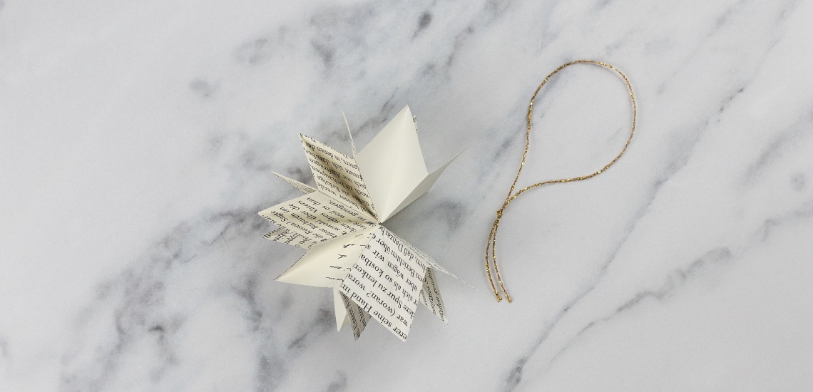 aneinander geklebte Papierquadrate mit Kordel zum Aufhängen