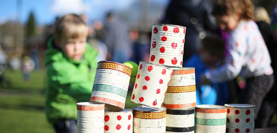 Zu Pyramide gestapelte bunt bemalte Dosen bei Kindergeburtstag 