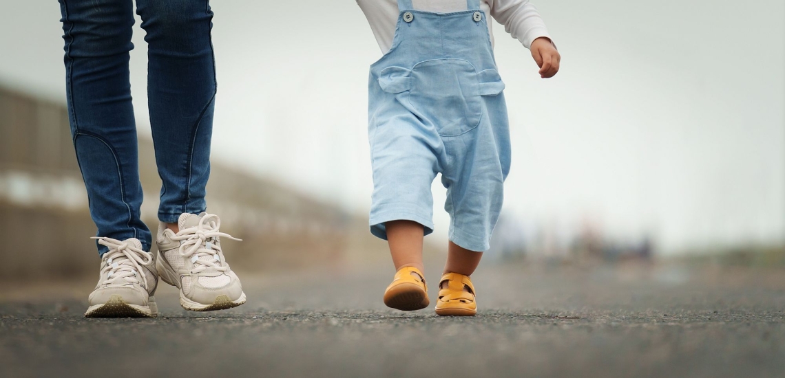 Mutter und Kleinkind laufen auf der Straße