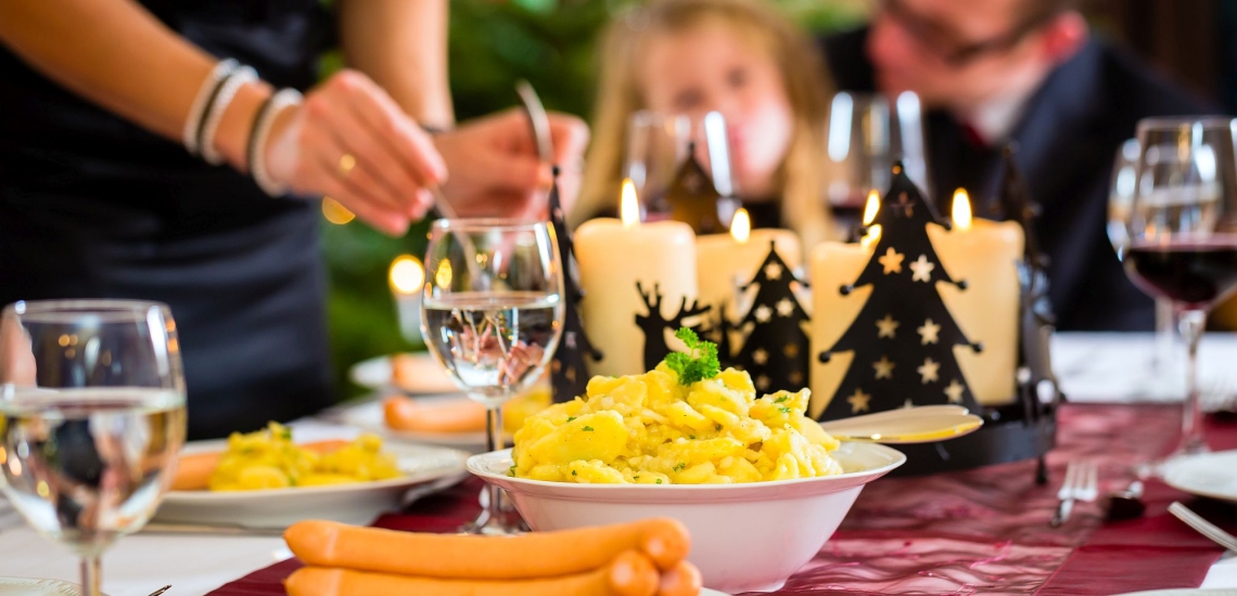 Festlich gedeckter Tisch mit typisch deutschem Weihnachtsessen Würstchen und Kartoffelsalat 