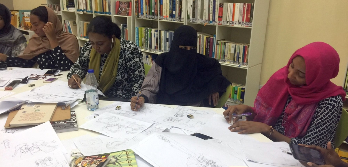 Frauen an Tisch mit Bildern und Stiften bei Workshop von Ute Kraus im Sudan 