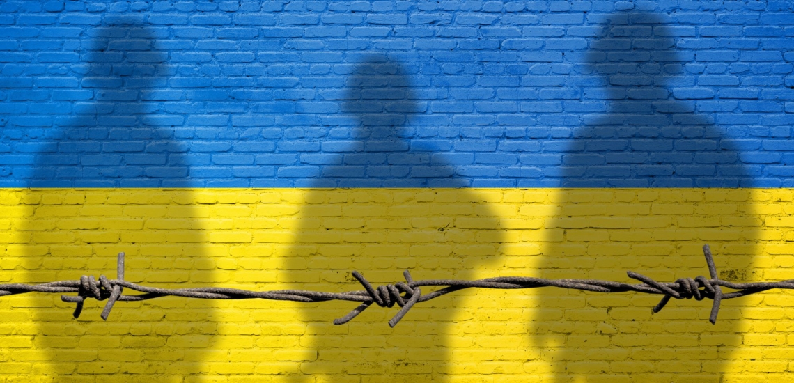 Farben blau und gelb der ukrainischen Flagge mit Stacheldraht und Schatten von drei Soldaten