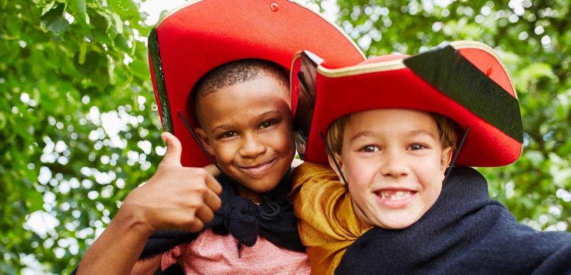 zwei Jungen verkleidet mit Hüten und Umhängen 