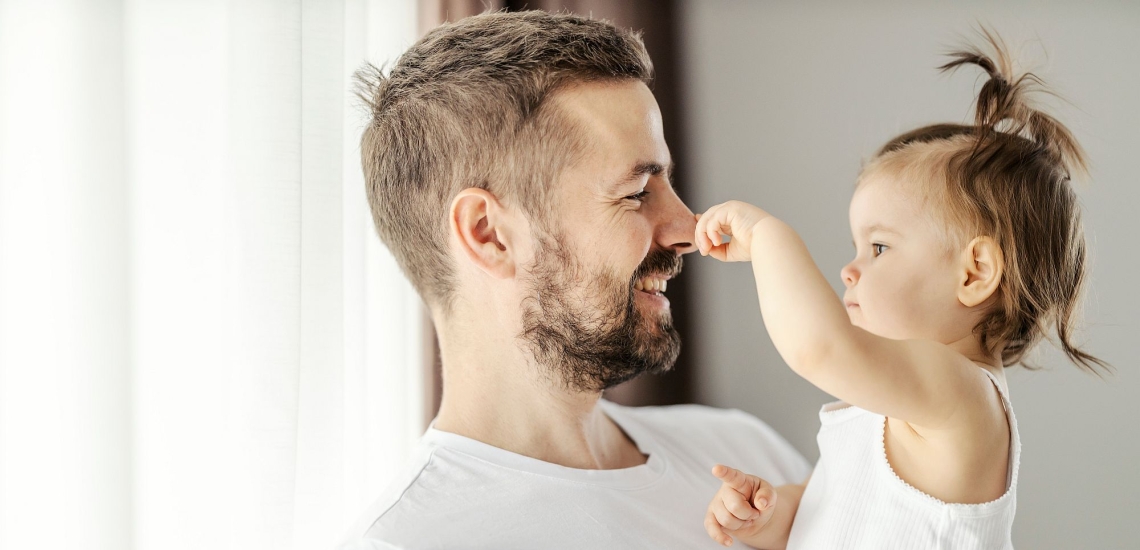 Vater und Kleinkind scherzen miteinander 