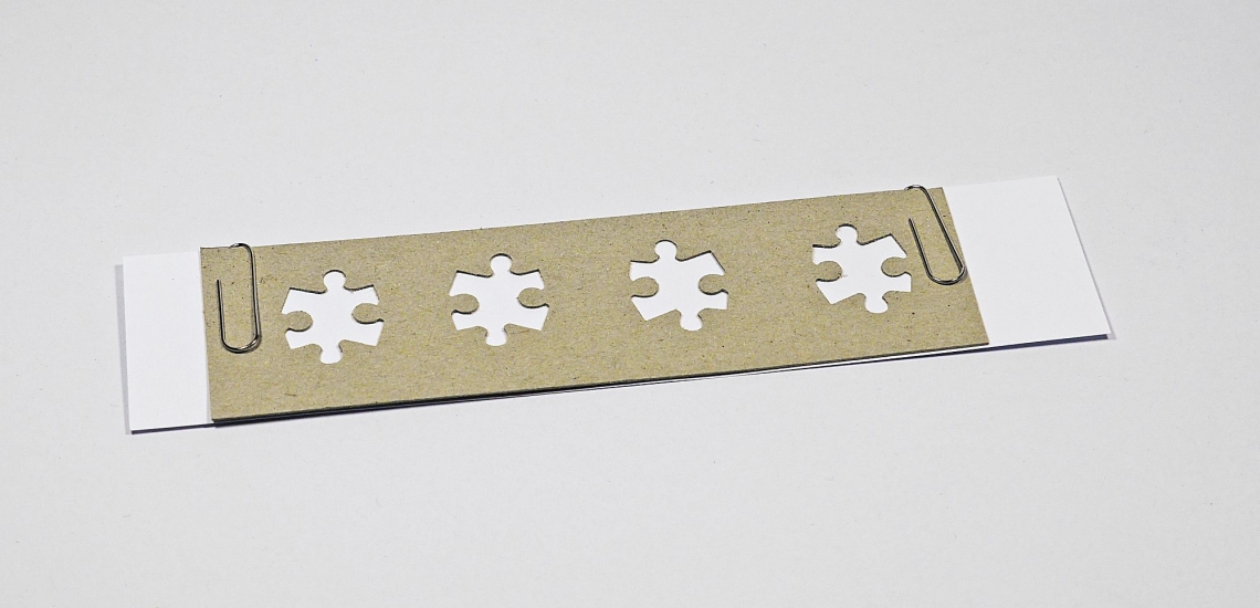 Druckschablone wird an Papierstreifen befestigt