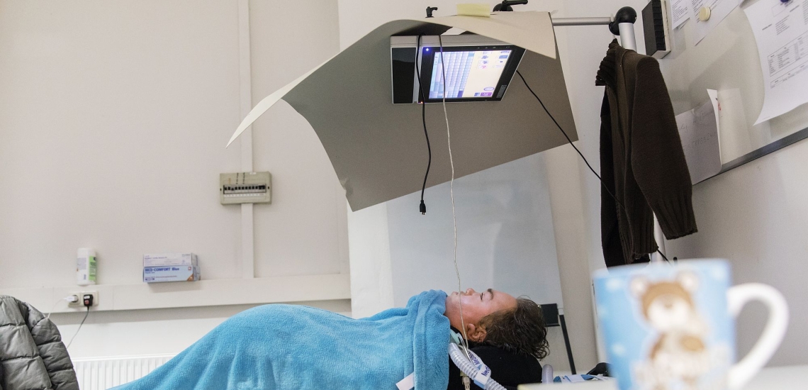 Alexander Greis im Rollstuhl mit Bildschirm über dem Kopf