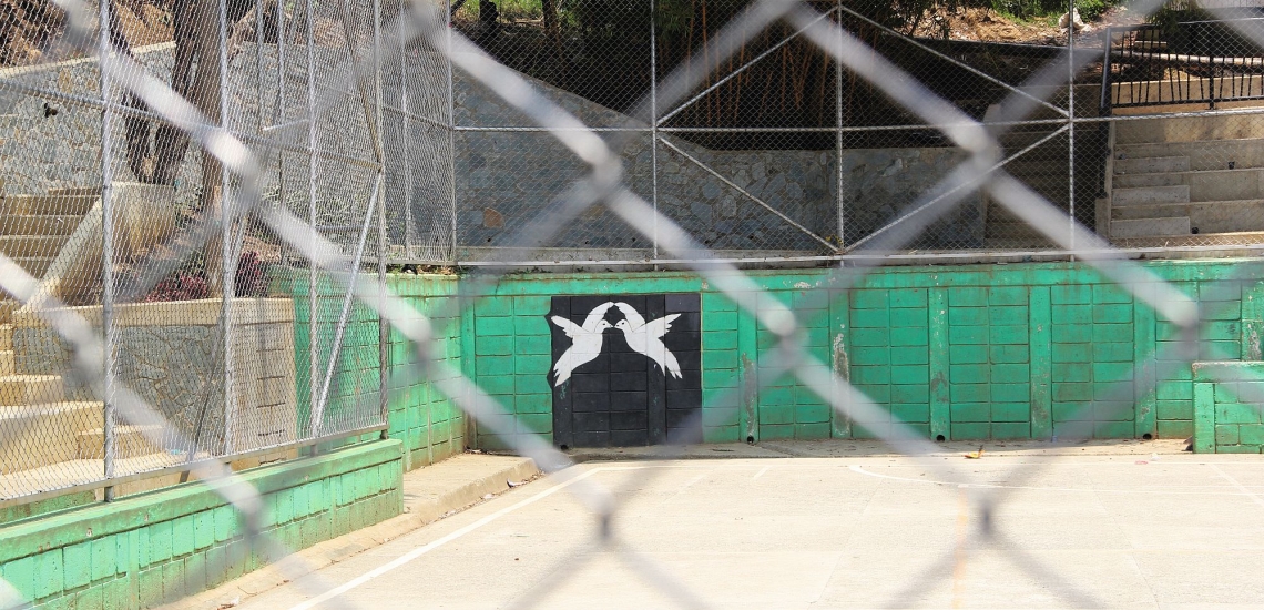 Sportplatz mit Bild von Friedenstauben auf einer Mauer