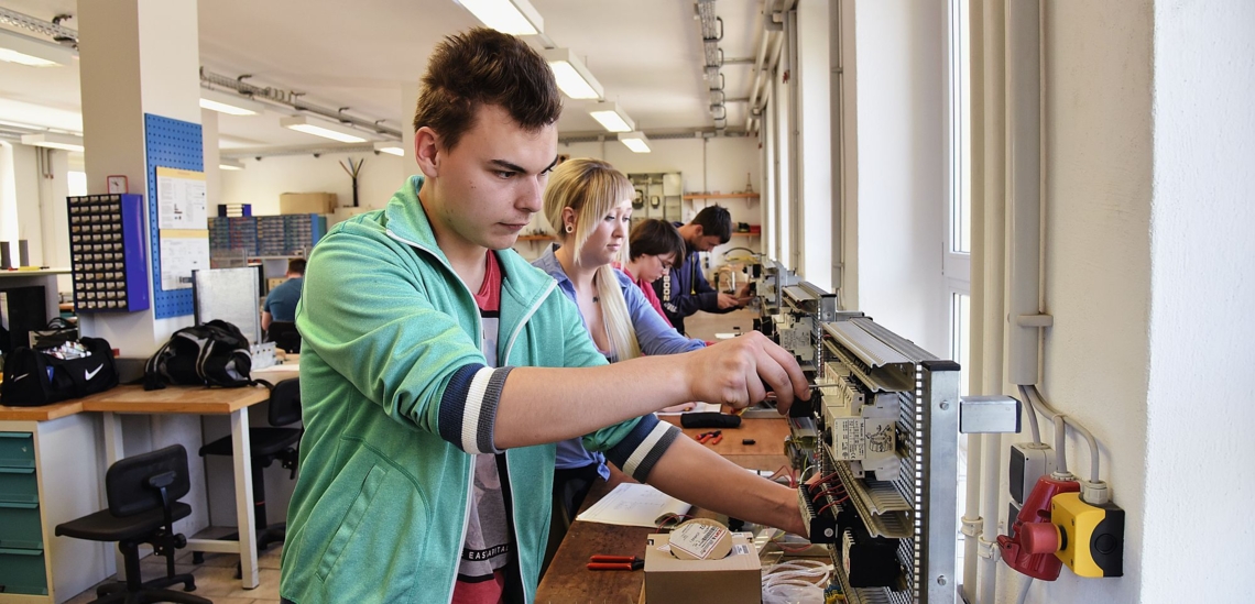 Junger Mann arbeitet an elektrischen Geräten im Don Bosco Jugend-Werk Sachsen 